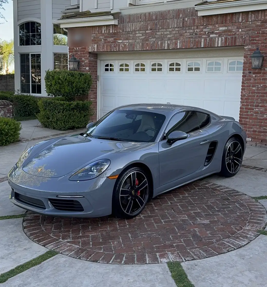 Grey Porsche 718 detailed in a brick driveway