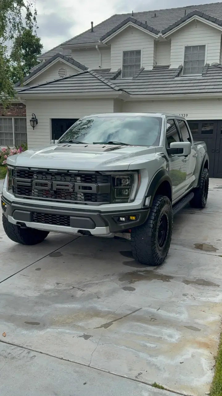 White Ford Raptor on a clean driveway after a maintenance detail