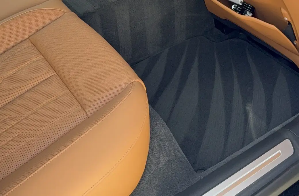 Detailed brown leather interior and clean floor of a white SUV